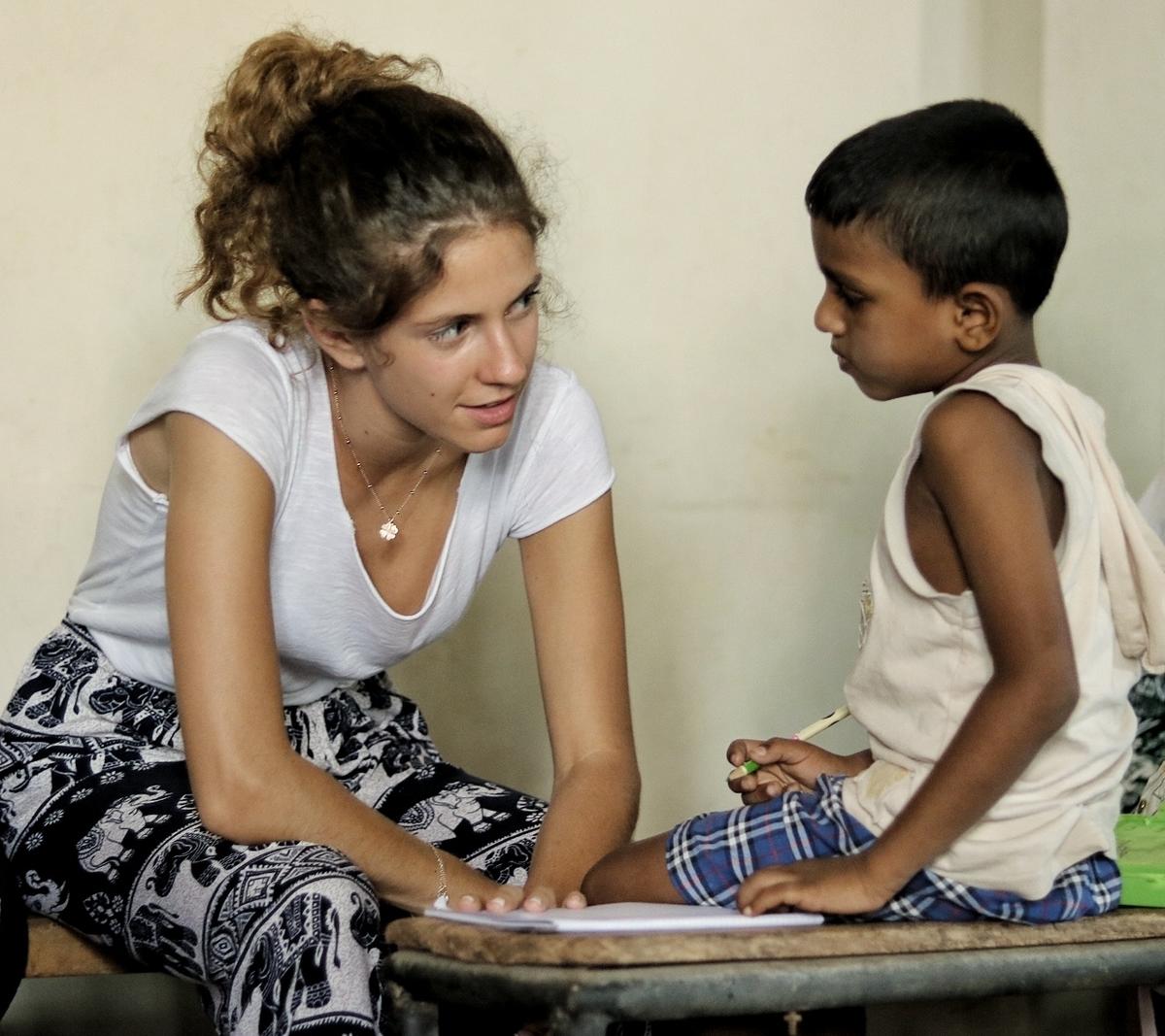 A Projects Abroad volunteer sits with a child in Sri Lanka An alternative schoolies volunteer speaks with a child while doing volunteer work in Sri Lanka